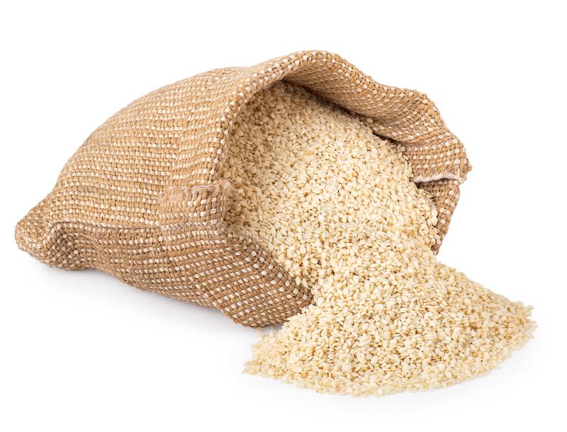 Clean white sesame seeds spilling from a woven sack